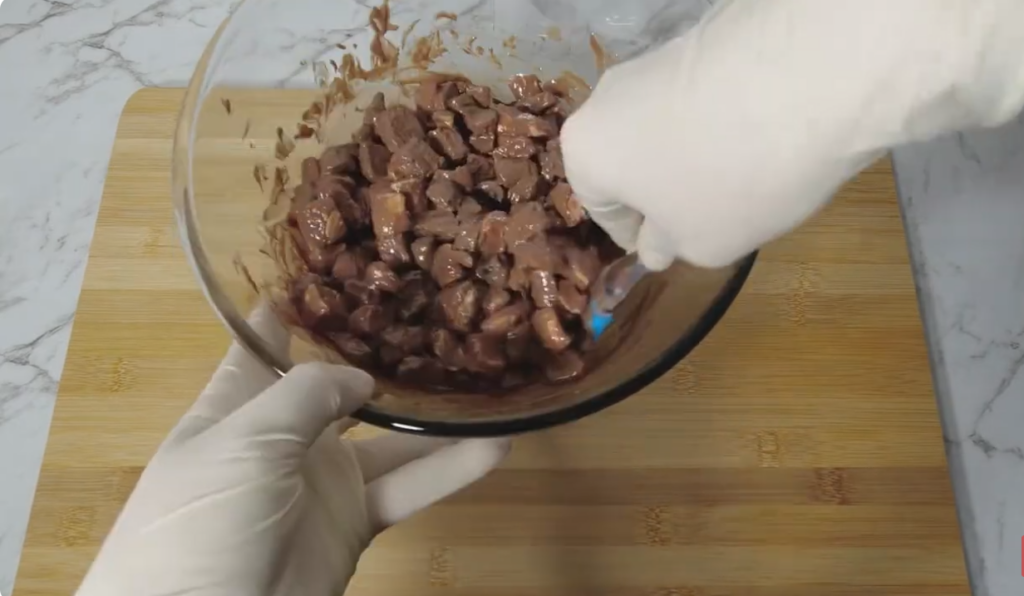 Melted chocolate being mixed with lollies, marshmallows and biscuit pieces