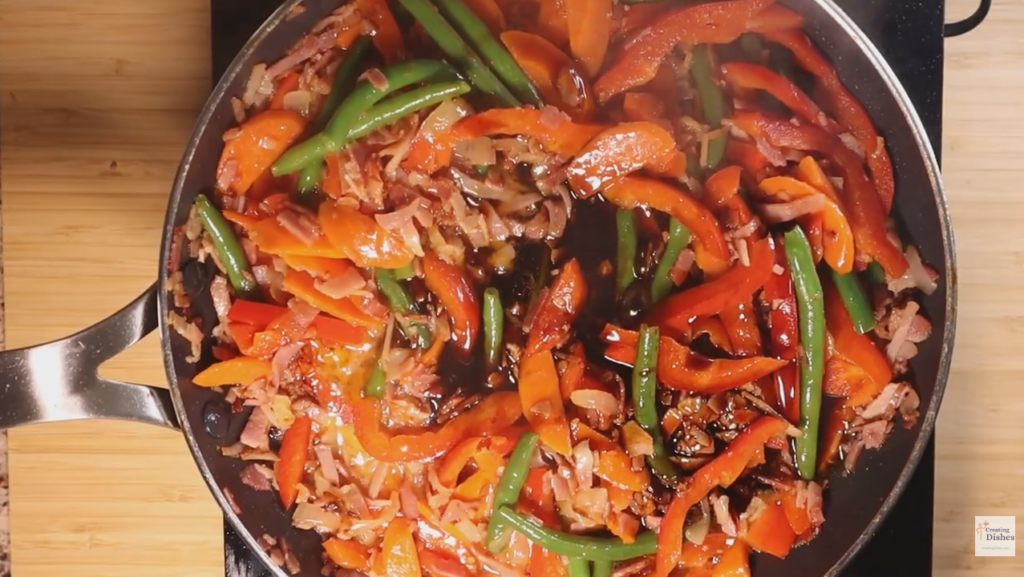 Adding sauce to Hokkien Noodles meat and vegetables. in a fry pan