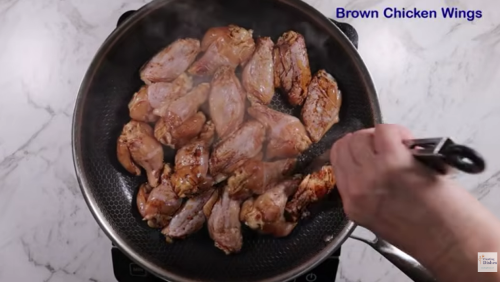 Chicken wings, browning skin side down in a frying pan